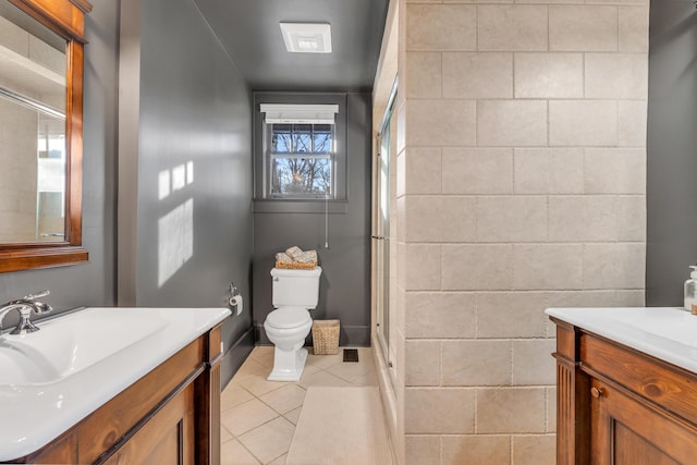 bathroom featuring tile patterned flooring, a shower with shower door, vanity, and toilet