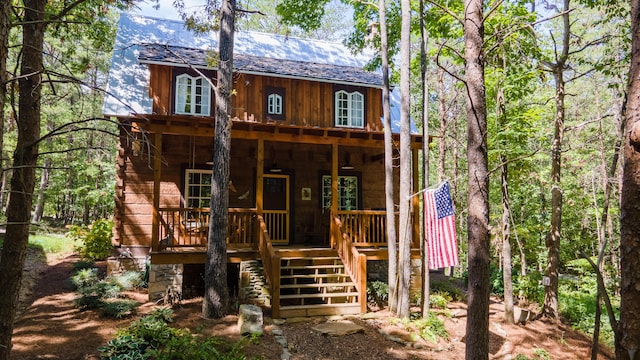 view of front facade with covered porch, stairs, and board and batten siding