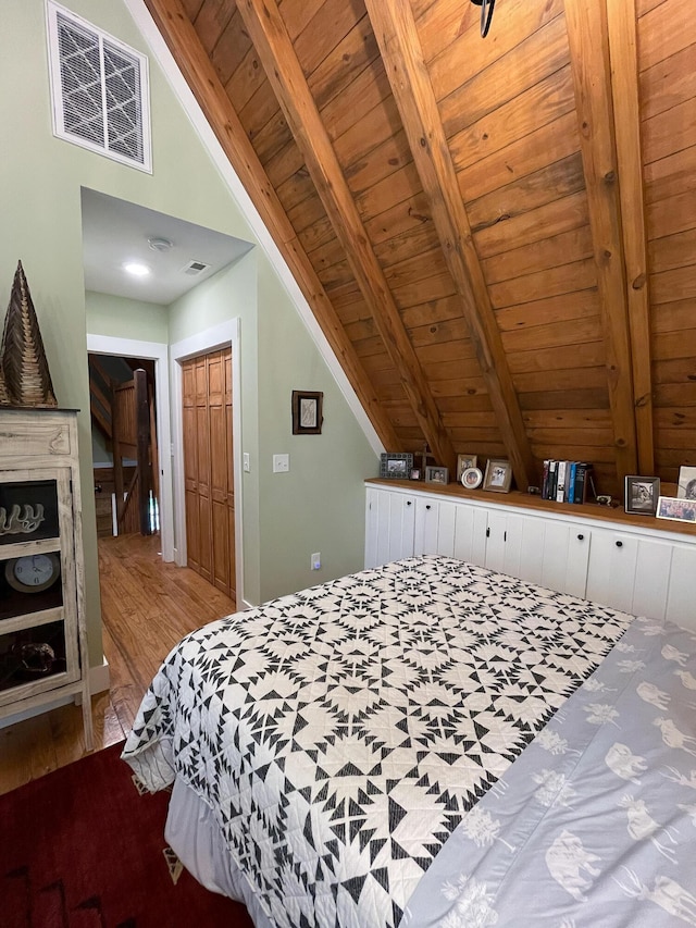 bedroom featuring vaulted ceiling with beams, wooden ceiling, wood finished floors, and visible vents