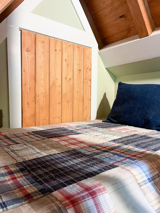 unfurnished bedroom featuring a closet and vaulted ceiling with beams