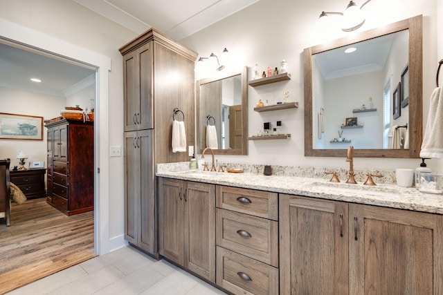 full bath featuring crown molding, wood finished floors, a sink, and double vanity