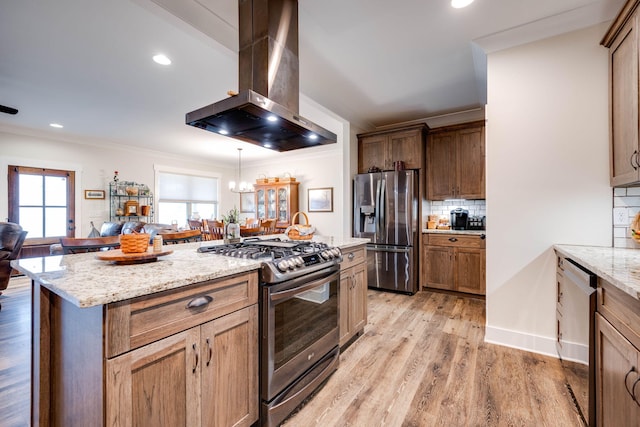 kitchen with light wood-style floors, appliances with stainless steel finishes, ornamental molding, wall chimney range hood, and backsplash