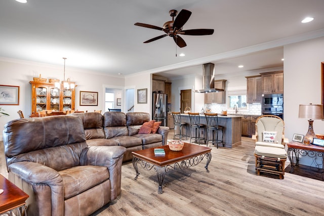 living room with ornamental molding, recessed lighting, and light wood finished floors