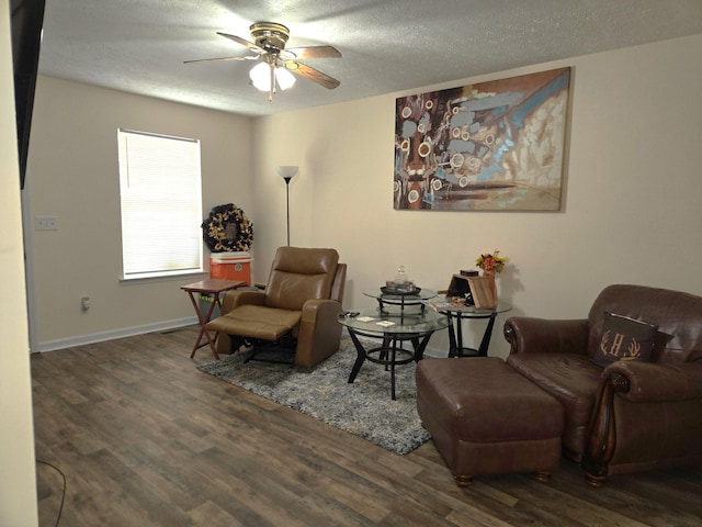 living area with a textured ceiling, ceiling fan, wood finished floors, and baseboards