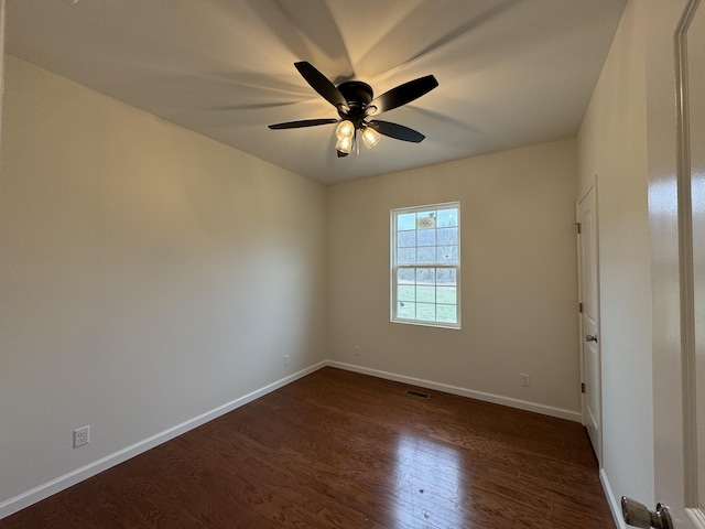 empty room with dark wood-type flooring, visible vents, baseboards, and a ceiling fan