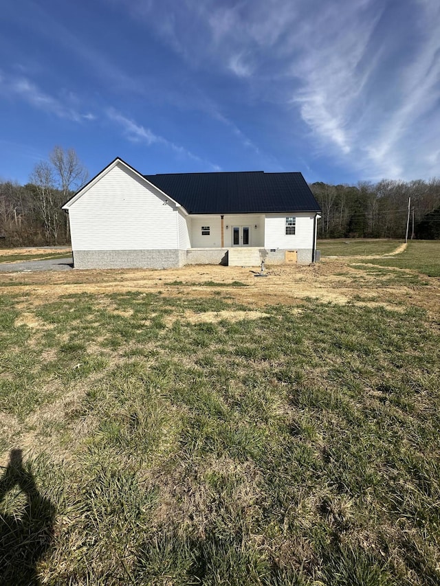 back of house with a yard and metal roof