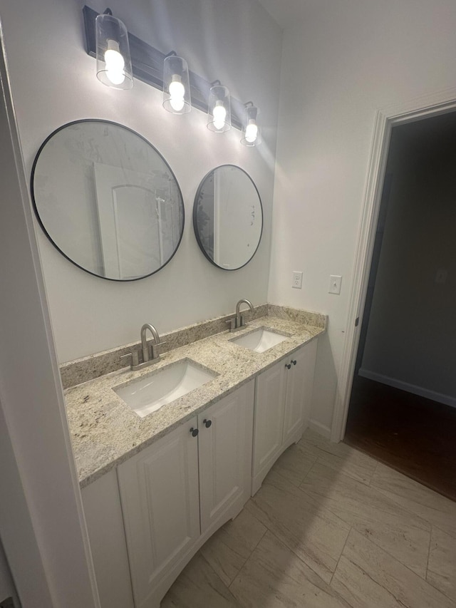 bathroom featuring marble finish floor, a sink, and double vanity