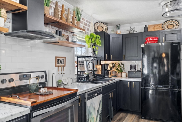 kitchen featuring dishwasher, open shelves, wall chimney range hood, and freestanding refrigerator