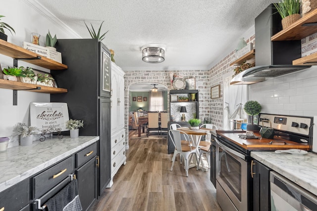 kitchen with arched walkways, open shelves, exhaust hood, and stainless steel range with electric cooktop