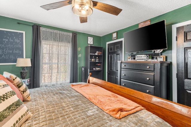 bedroom with a ceiling fan and a textured ceiling