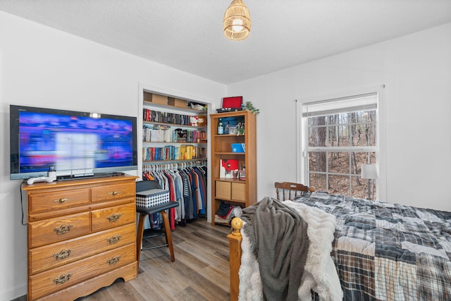 bedroom with a closet, a textured ceiling, and wood finished floors