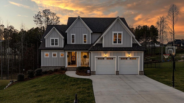 view of front of home featuring fence, a shingled roof, concrete driveway, a lawn, and board and batten siding