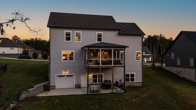 back of house featuring a yard, a patio area, a garage, and a sunroom