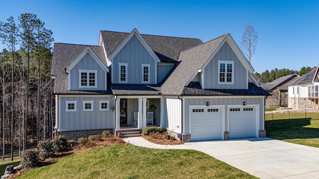 view of front of home featuring driveway, board and batten siding, a front yard, and fence