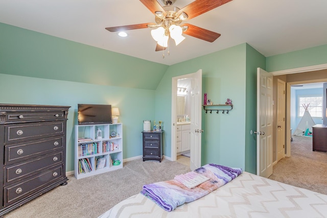 bedroom featuring connected bathroom, light carpet, a ceiling fan, baseboards, and vaulted ceiling