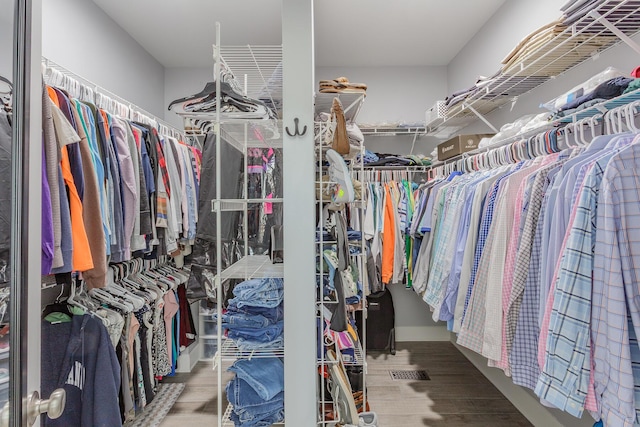 walk in closet with wood finished floors