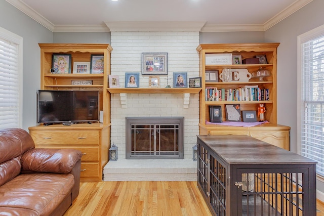 living area with ornamental molding, a fireplace, and wood finished floors