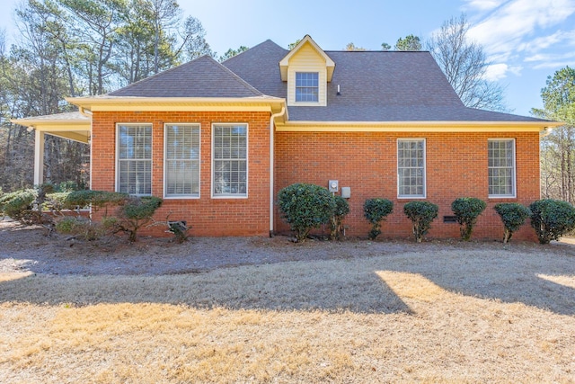 view of property exterior with brick siding and a shingled roof