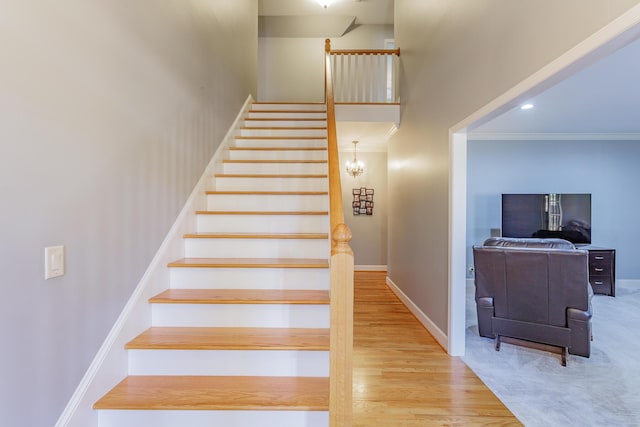 staircase featuring recessed lighting, wood finished floors, a towering ceiling, baseboards, and crown molding