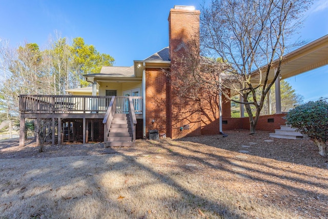 back of house with a chimney, crawl space, stairs, a deck, and brick siding