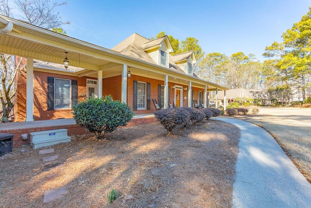 exterior space with brick siding and a porch