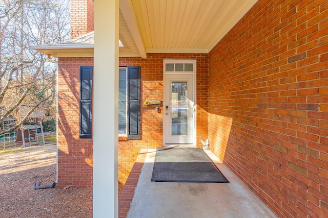 entrance to property featuring brick siding