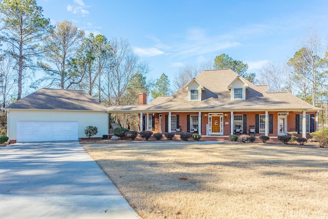 view of front of home with driveway, a porch, a front yard, and brick siding