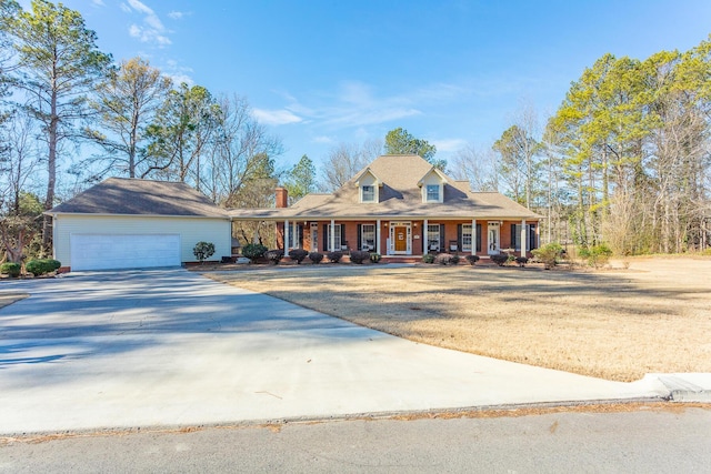 view of front of house featuring a porch, a front yard, concrete driveway, and an attached garage