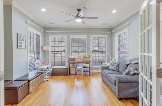 living area featuring french doors, wood finished floors, a ceiling fan, and crown molding