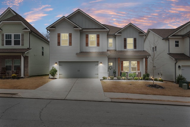 view of front facade featuring board and batten siding, driveway, and a garage