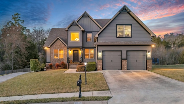 craftsman house with a garage, a yard, board and batten siding, and driveway