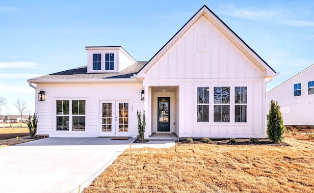 modern inspired farmhouse with french doors, board and batten siding, and a shingled roof