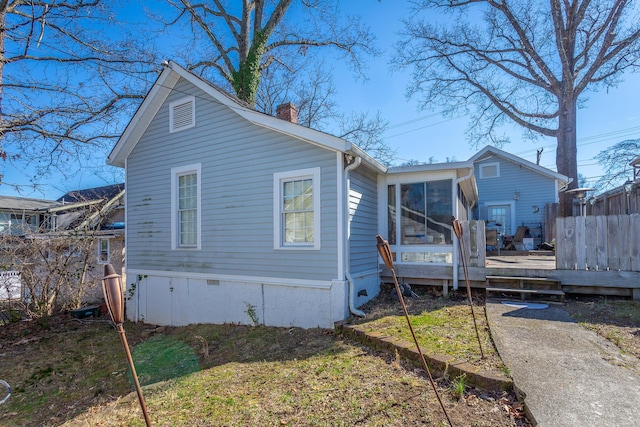 rear view of house featuring crawl space, a sunroom, a chimney, and a wooden deck