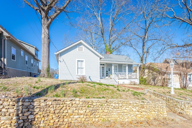 view of front of home with a chimney and a porch