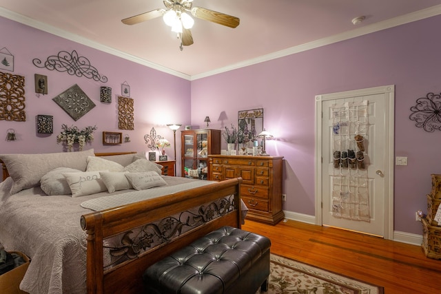 bedroom with light wood-style floors, ornamental molding, baseboards, and ceiling fan