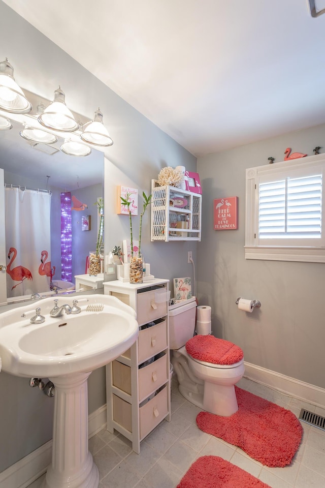 full bath with tile patterned flooring, toilet, a shower with shower curtain, visible vents, and baseboards