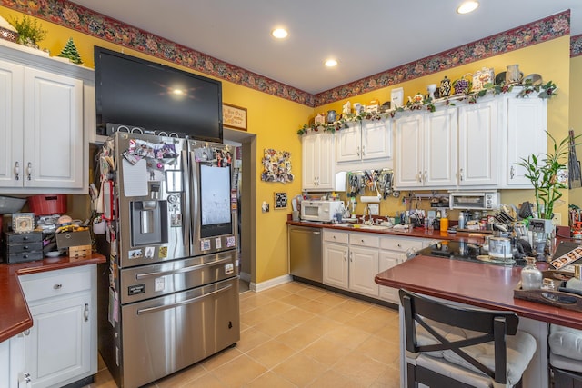 kitchen with white cabinets, dark countertops, and stainless steel appliances