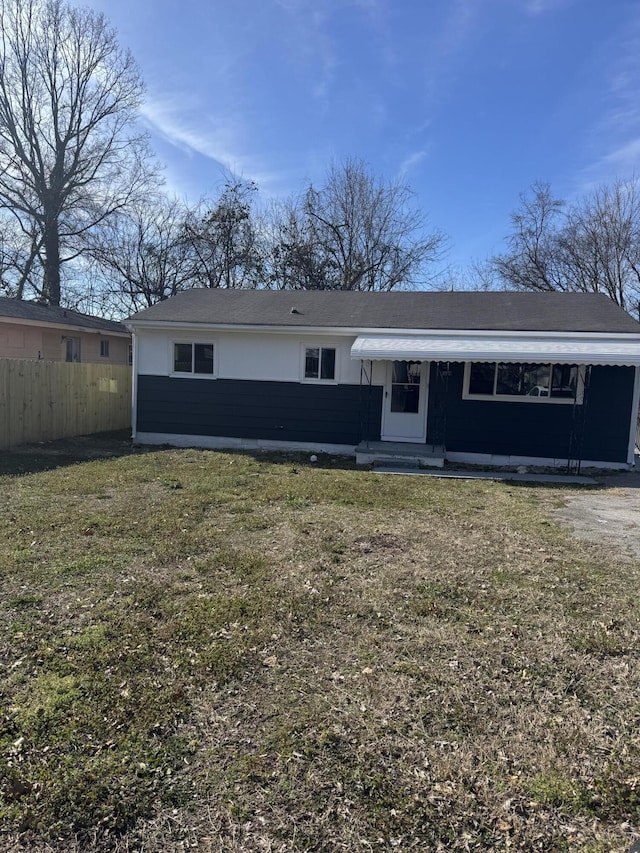 view of front of property with fence and a front lawn