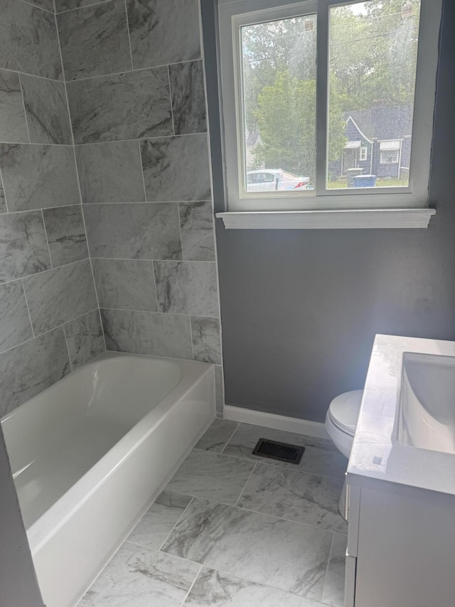bathroom with toilet, vanity, marble finish floor, baseboards, and visible vents