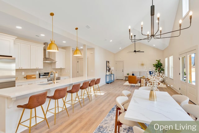 dining space with light wood finished floors, baseboards, ceiling fan, high vaulted ceiling, and recessed lighting