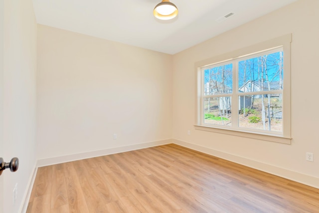 spare room featuring light wood-style floors and baseboards