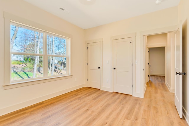 unfurnished bedroom featuring light wood-style floors and baseboards