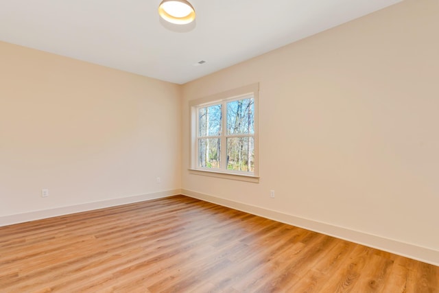 empty room with light wood finished floors and baseboards