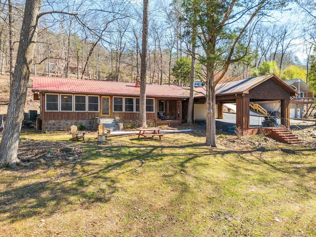 view of front of house with a carport, a front yard, and metal roof