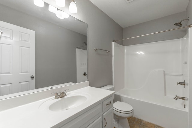 bathroom featuring tile patterned flooring, bathtub / shower combination, vanity, and toilet