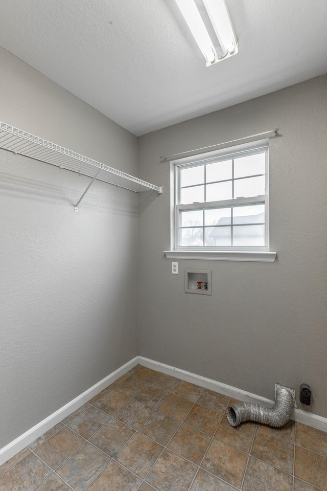 laundry area featuring washer hookup, laundry area, a textured ceiling, and baseboards