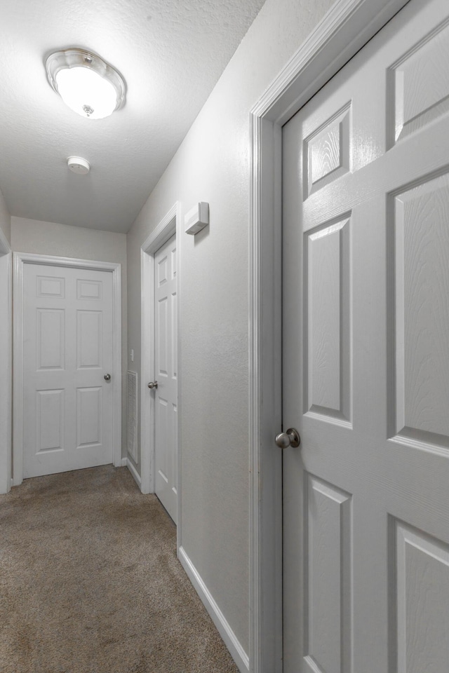 hall with carpet flooring and baseboards