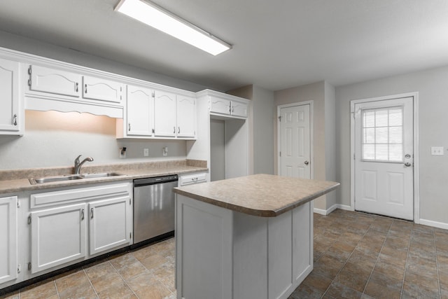 kitchen with a kitchen island, a sink, baseboards, white cabinets, and dishwasher