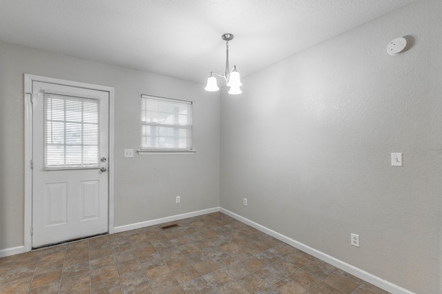 interior space with baseboards, visible vents, and an inviting chandelier