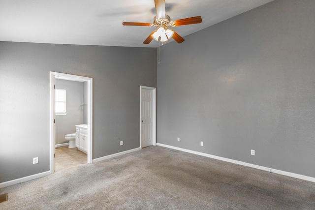 unfurnished bedroom with light carpet, baseboards, a ceiling fan, ensuite bath, and vaulted ceiling